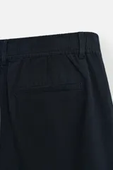 Bermuda azul marino de corte regular, confeccionada en tejido de algodón y lino. Cuenta con bolsillos frontales y traseros, cierre frontal con cremallera y botón.