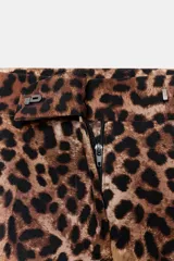 Pantalón largo de tiro alto con estampado animal print de leopardo en tonos marrones. Tiene bolsillos laterales y cierre frontal con cremallera, botón interior y gancho metálico.