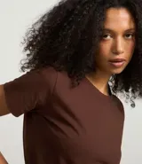 Blusa básica de algodón color tostado, de manga corta con dobladillo y nudo frontal.