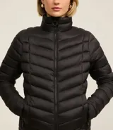 Campera puffer ultraligera color marrón, confeccionada en poliamida acolchada, con cuello alto y cierre por cremallera. Incluye bolsita con cordón.