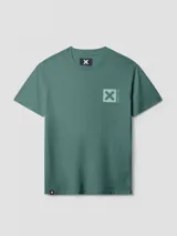 Camiseta de manga corta color azul grisáceo, con un gran estampado cuadrado turquesa en la espalda que contiene una 'X' blanca. Pequeño logo bordado en la parte superior de la espalda.