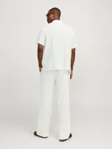 Camisa blanca de popelina con cuello resort, mangas cortas y cierre frontal con botones.