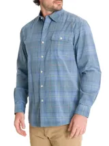 Camisa de franela de algodón orgánico a cuadros en tonos azul, gris y verde. Tiene cuello camisero, manga larga, un bolsillo en el pecho y cierre con botones.