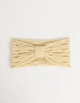 Vincha color beige de tejido de punto trenzado con detalle de lazo en el centro.