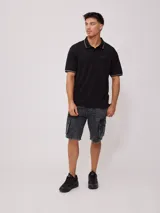 Remera polo negra de corte regular, con cuello y mangas con rayas en contraste blancas y logo bordado en el pecho.