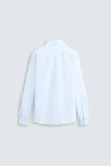 Camisa celeste a rayas verticales blancas, de corte recto, con cuello italiano abierto, mangas largas con puños abotonados y cierre frontal con botones.