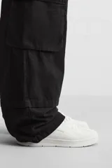 Zapatilla deportiva negra de estilo retro con suela de goma con volumen.