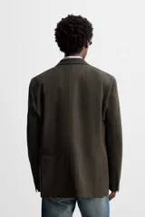 Blazer straight fit color marrón oscuro con finas rayas verticales claras. Confeccionado en tejido con lana de origen italiano. Cuello con solapas de muesca y manga larga acabada en puño con botones. Bolsillos de vivo en pecho y de solapa en cadera. Detalle de bolsillo interior. Bajo con aberturas en espalda. Cierre frontal de botonadura.