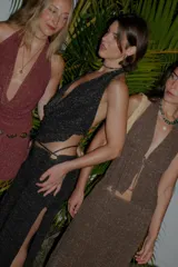 Falda larga tejida color vino tinto con brillo dorado, de corte ajustado y abertura lateral en la pierna.