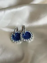 Aros colgantes circulares con centro de resina verde oscuro y borde de strass plateado.
