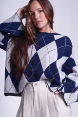 Sweater de punto con diseño de rombos en tonos marrón y beige, de mangas largas y corte holgado.