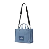 Bolso tote negro de lona con asas de mano y correa bandolera ajustable. Estampado frontal con la leyenda "THE TOTE BAG MARC JACOBS" en letras blancas.