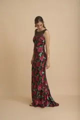 Vestido largo de fiesta color negro, con escote redondo y bordado de lentejuelas formando flores rojas y verdes.