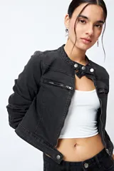 Campera entallada de denim con estampado animal print de cebra en tonos beige y negro. Tiene cuello mao con broches metálicos, cierre frontal con cremallera, bolsillos con cierre en el pecho y mangas largas con puños con cierre.