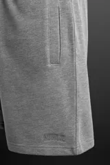Bermuda gris melange de corte jogger, confeccionada en tejido de algodón con interior de rizo. Cuenta con cintura elástica ajustable con cordón, bolsillos frontales de vivo y logo bordado en el bajo.