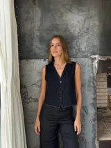 Chaleco sastrero blanco con pespuntes en contratono, escote en V y cierre frontal con botones.