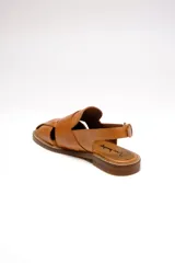 Sandalia negra de cuero con diseño tejido, puntera redondeada, talón descubierto y tira trasera con hebilla dorada ajustable.