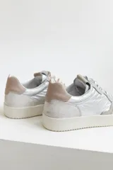 Zapatillas urbanas de cuero negro con cordones negros y suela blanca.