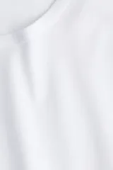 Remera blanca de algodón suave con cuello redondo ribeteado y bajo recto.