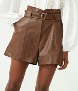 Short marrón de cuero sintético, tiro alto, corte clochard, con cinturón con hebilla metálica.