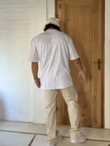 Remera blanca de algodón, corte amplio y mangas cortas.