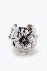Pulsera rígida plateada con diseño de flores en relieve.