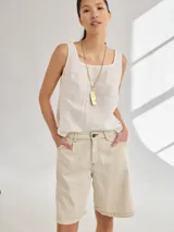 Bermuda color beige de tiro medio/alto, calce cómodo y relajado, con detalle de volados en los bolsillos.