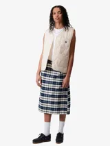 Chaleco negro Carhartt WIP W' Skyler con costuras y textura puffer. Borde tonal en el cuello en V, cierre de botón a presión tonal en la abertura frontal, bolsillo de parche del mismo tejido en el pecho izquierdo y 2 bolsillos de parche del mismo tejido en la parte delantera inferior.