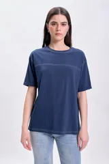 Remera azul marino de corte recto y mangas cortas con dobladillo. Presenta pespuntes contrastados en color blanco en cuello, ruedo y dos líneas horizontales en el pecho.