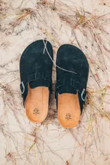 Zuecos negros con hebilla metálica ajustable.