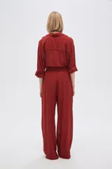 Pantalón negro ancho de viscosa con bolsillos laterales y cintura alta con cordón ajustable.