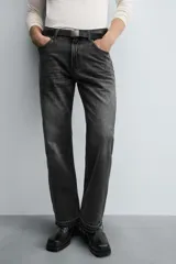 Pantalón de jean celeste de corte flare, con tiro medio, cinco bolsillos, cierre frontal con cremallera y botón, y bajo con acabado irregular.