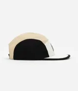 Gorra de microfibra beige y negra, modelo de 5 paneles con visera plana, etiqueta frontal y ajuste trasero con velcro.