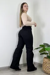 Pantalón de jean negro, corte wide leg, tiro alto y confeccionado con licra.
