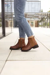 Botas de cuero marrón con detalle en costura lateral y cierre en el lateral.