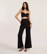 Pantalón de vestir negro, de corte palazzo, sin cintura, con pliegues y cierre trasero.