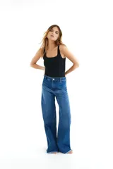 Pantalón de jean azul de corte wide leg con terminación desflecada.