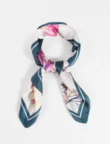 Pañuelo cuadrado de seda con estampado floral multicolor y borde azul petróleo con línea blanca.