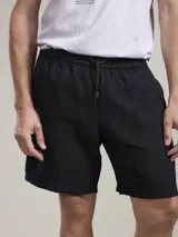 Bermuda negra de lino con cintura elástica y cordón ajustable.