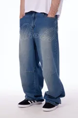 Pantalón de jean oversized de tiro bajo, color azul lavado, con grabado láser de la palabra "Blkmba" en el frente y "Worldwide" en la parte trasera.