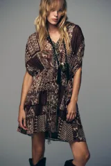 Vestido corto con estampado de cachemira en tonos marrones, beige y verde. Tiene escote en pico con abalorios, mangas cortas y cintura elástica con cinturón fino.