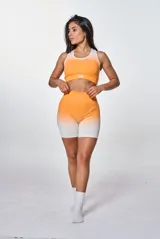 Conjunto deportivo de calza corta y top, color naranja con degradado a blanco. El top es de corte deportivo con logo "bk." en el frente.