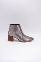 Bota corta plateada de cuero, con punta fina y taco de madera.