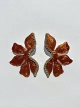 Par de aros con forma de flor roja brillante y detalle de strass plateado en el centro.