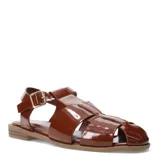 Sandalias franciscanas chatas color marrón de charol, con tiras anchas cruzadas y hebilla dorada.