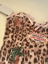 Corset elastizado animal print con detalles de encaje y moños en rosa.