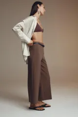Pantalón culotte color verde oliva, de tiro medio y pierna ancha. Incluye cinturón ajustable con hebilla metálica y cierre lateral con cremallera oculta.