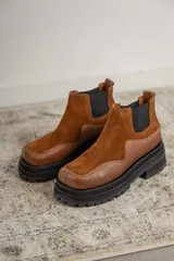 Botas Chelsea de cuero color marrón con paneles laterales elásticos negros y suela track de goma negra.