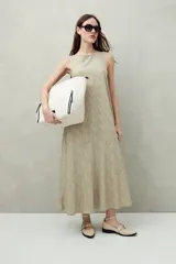 Vestido largo color beige con estampado abstracto, sin mangas y con cuello redondo.
