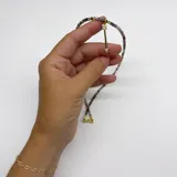 Collar elaborado con mini cuentas facetadas de turmalina multicolor y un dije colgante en forma de flecha dorada con incrustaciones de cristales.